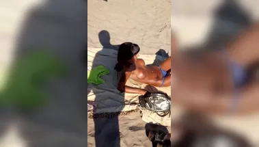 Скрытная съемка грудастой брюнетки топлес на общественном пляже
